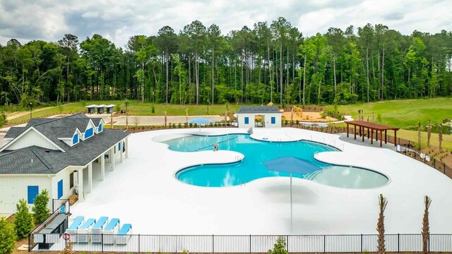 view of pool with an outbuilding, a patio, and a yard