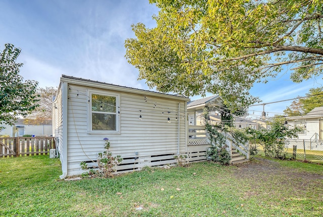 rear view of house featuring a yard and a wooden deck