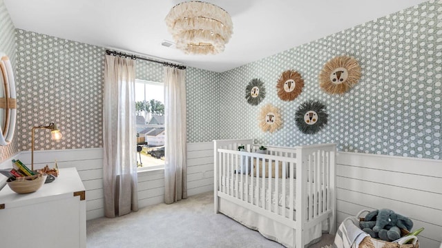 bedroom featuring wainscoting and wallpapered walls