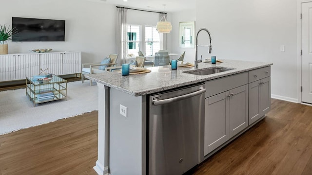 kitchen featuring pendant lighting, gray cabinetry, a sink, an island with sink, and dishwasher