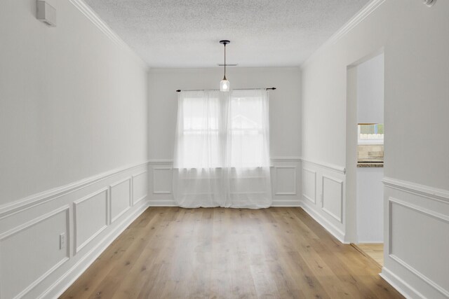 509 Hill St, Moncks Corner, SC 29461 - unfurnished dining area featuring plenty of natural light, crown molding, a wainscoted wall, a textured ceiling, and light wood-style floors