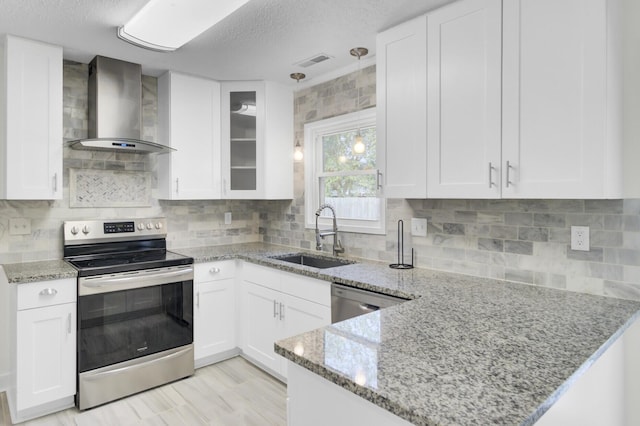 509 Hill St, Moncks Corner, SC 29461 - kitchen featuring appliances with stainless steel finishes, wall chimney range hood, a sink, white cabinetry, and a textured ceiling