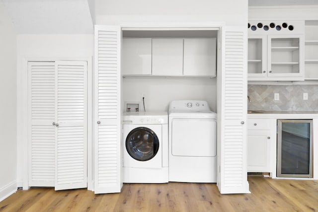 509 Hill St, Moncks Corner, SC 29461 - laundry area featuring wine cooler, cabinet space, washer and clothes dryer, and light wood-style flooring
