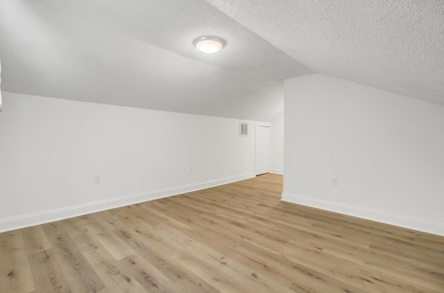 509 Hill St, Moncks Corner, SC 29461 - additional living space featuring lofted ceiling, baseboards, light wood finished floors, and a textured ceiling
