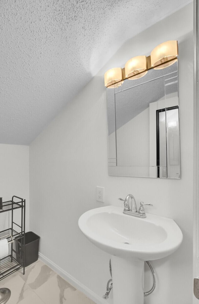 509 Hill St, Moncks Corner, SC 29461 - bathroom featuring a textured ceiling, vaulted ceiling, a sink, and marble finish flooring