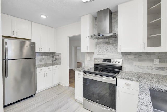 509 Hill St, Moncks Corner, SC 29461 - kitchen with stainless steel appliances, wall chimney range hood, backsplash, white cabinets, and a textured ceiling