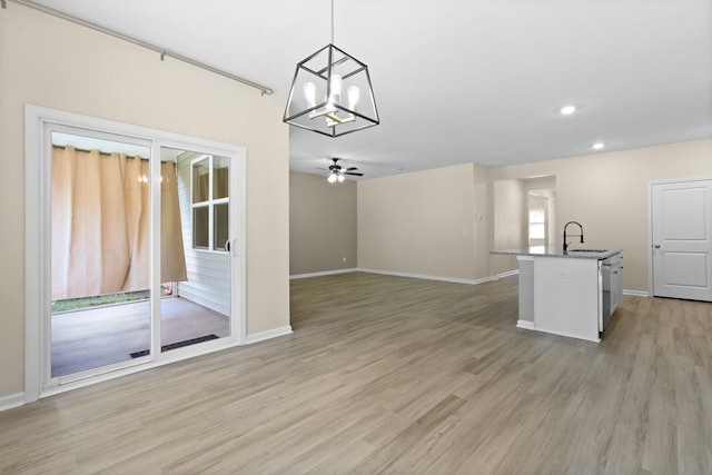 318 Bering Ln, Summerville, SC 29486 - interior space featuring baseboards, an island with sink, light wood finished floors, and ceiling fan with notable chandelier