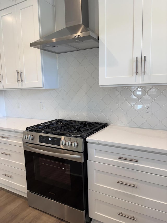 819 Burger St, Charleston, SC 29407 - kitchen with gas stove, wall chimney exhaust hood, white cabinets, light stone counters, and backsplash