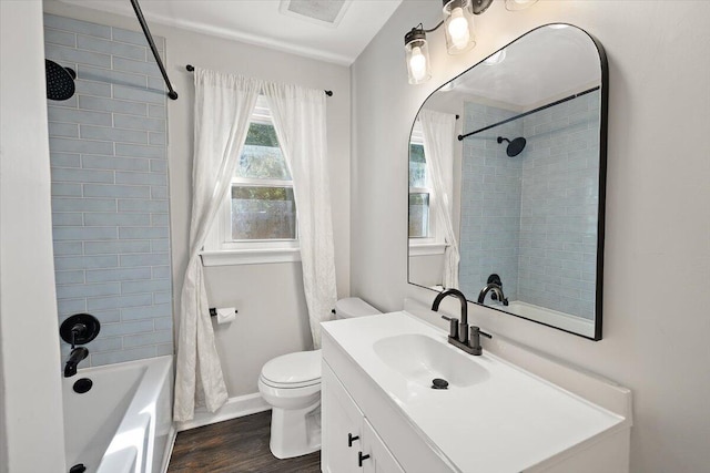 full bathroom with wood-type flooring, toilet, tiled shower / bath, and vanity