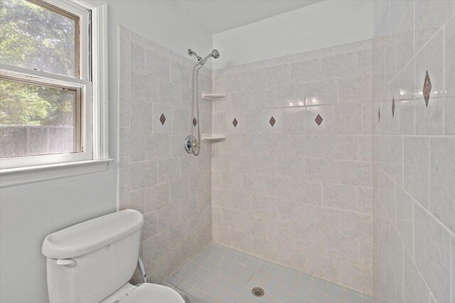 bathroom with toilet and a tile shower