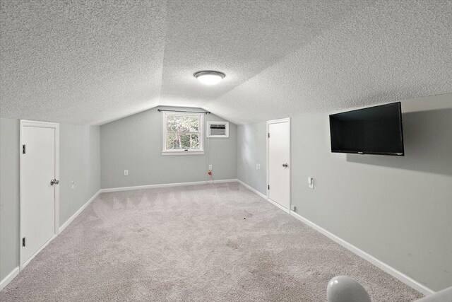 bonus room with a textured ceiling, carpet flooring, and vaulted ceiling