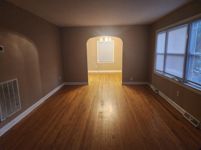 empty room featuring hardwood / wood-style floors and a notable chandelier