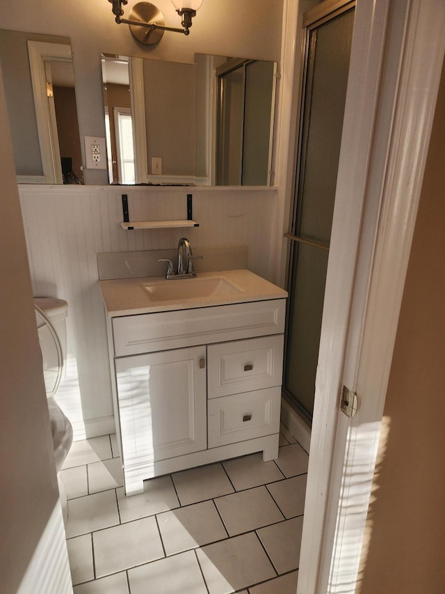 bathroom featuring walk in shower, vanity, and tile patterned flooring