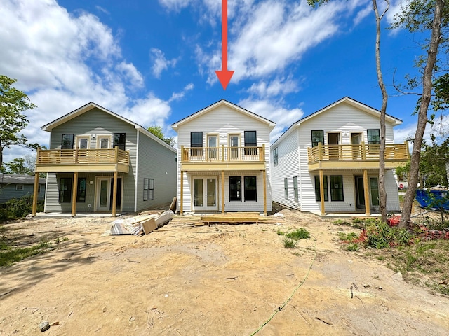 back of property featuring a balcony and french doors