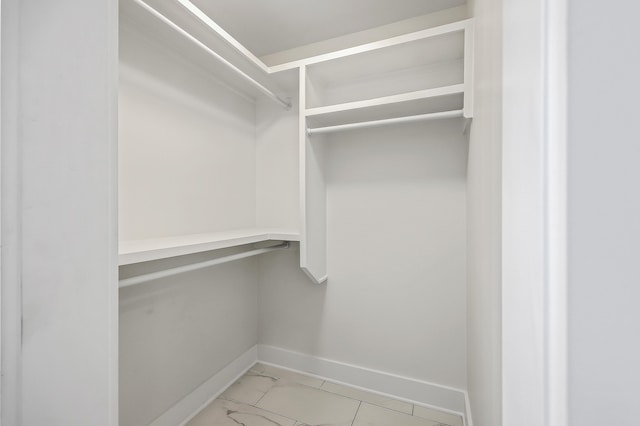 spacious closet featuring marble finish floor