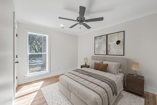 bedroom with ornamental molding, visible vents, and light wood-style flooring