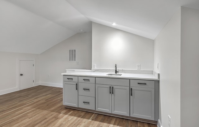 kitchen featuring light countertops, a sink, visible vents, and gray cabinetry