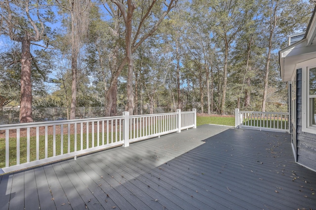 wooden deck featuring a yard and fence