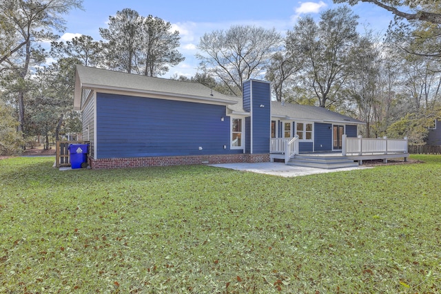 back of property with a chimney, a yard, a deck, and a patio