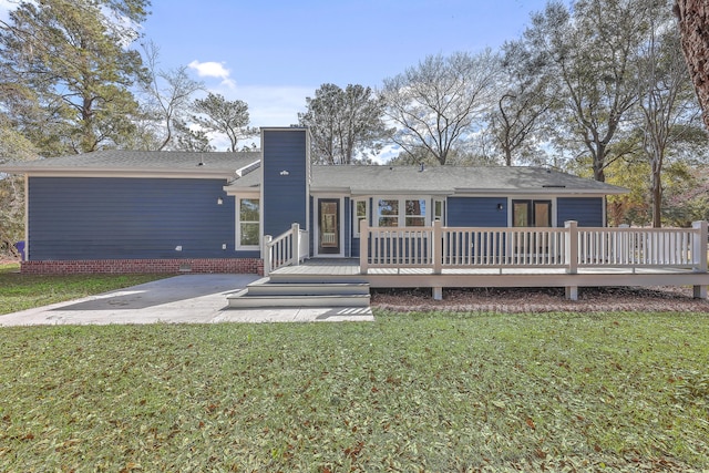 back of house with a yard, a chimney, crawl space, a patio area, and a wooden deck