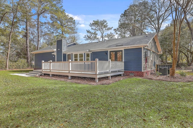 rear view of property with a yard, a chimney, crawl space, central AC, and a deck