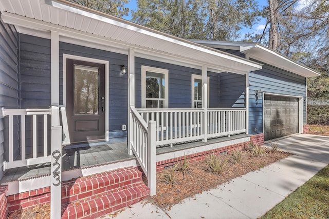 property entrance featuring driveway, covered porch, and an attached garage