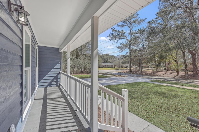 exterior space with covered porch and a yard