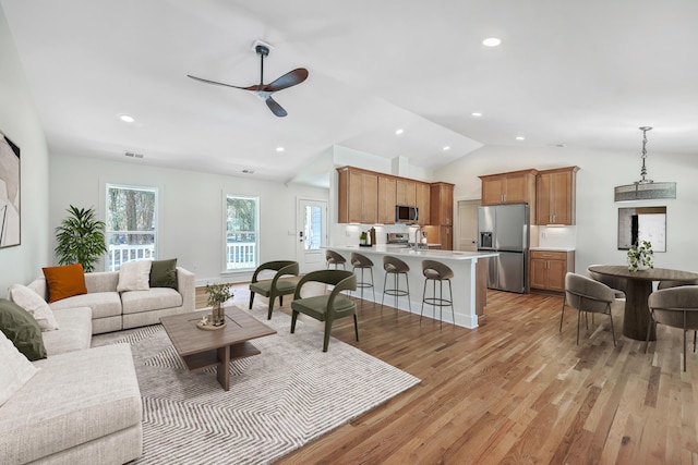 living room featuring lofted ceiling, recessed lighting, visible vents, light wood-style flooring, and ceiling fan