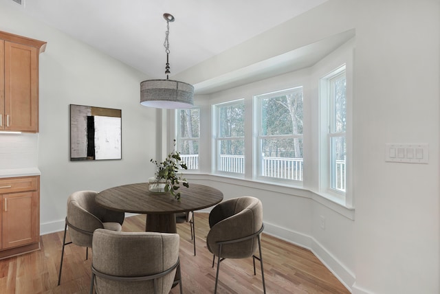 dining space with visible vents, light wood-style flooring, and baseboards