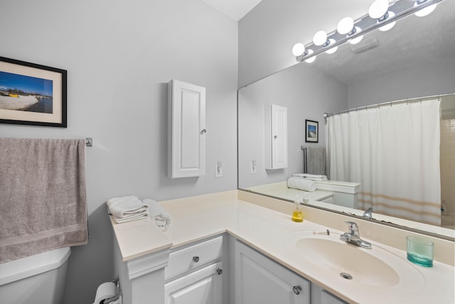 bathroom featuring vanity with extensive cabinet space and toilet