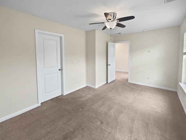 spare room with ceiling fan and carpet