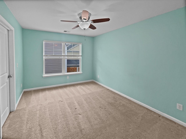 empty room featuring ceiling fan and carpet