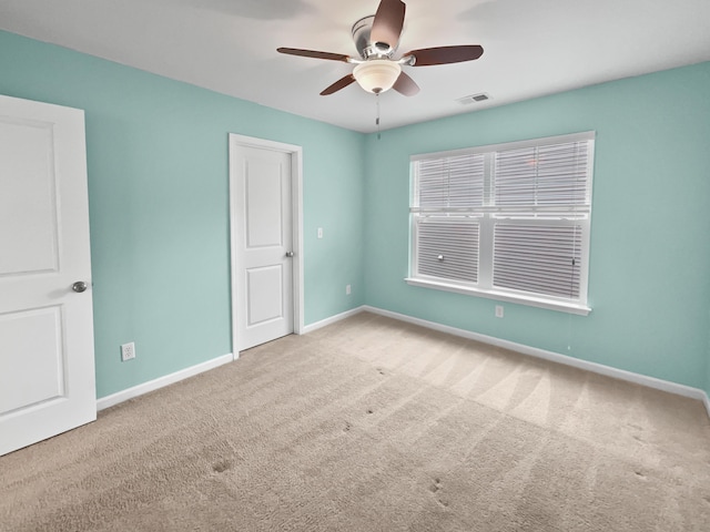 spare room featuring ceiling fan and light carpet