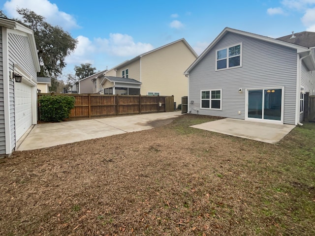 back of property featuring a patio area, a garage, and a lawn