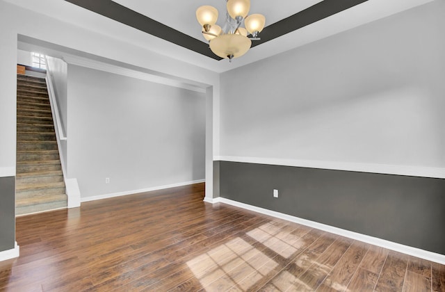 unfurnished room featuring a notable chandelier and dark hardwood / wood-style flooring