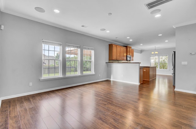 unfurnished living room with a notable chandelier, dark hardwood / wood-style flooring, and crown molding