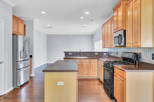 kitchen with stainless steel appliances, hardwood / wood-style floors, decorative backsplash, a center island, and ornamental molding