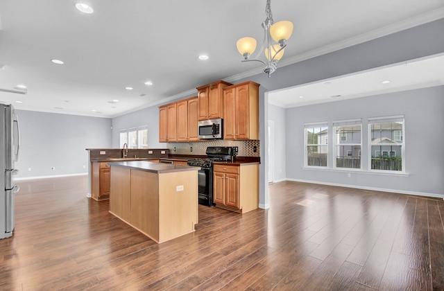 kitchen with an inviting chandelier, a center island, appliances with stainless steel finishes, decorative backsplash, and wood-type flooring