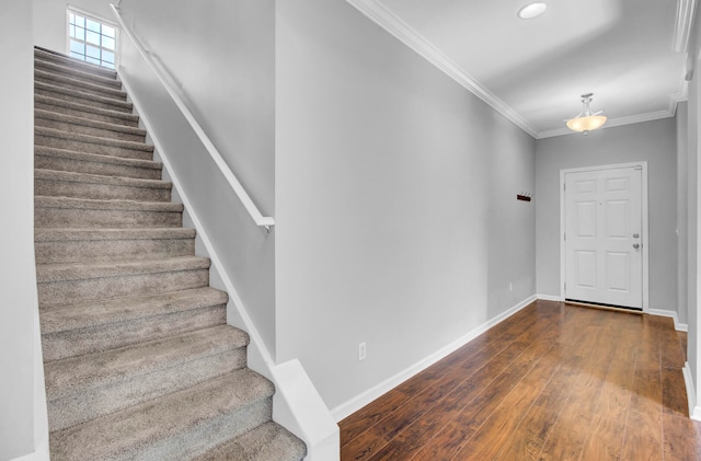 stairway with dark wood-type flooring and crown molding