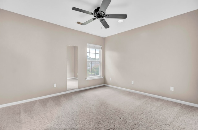 carpeted spare room featuring ceiling fan