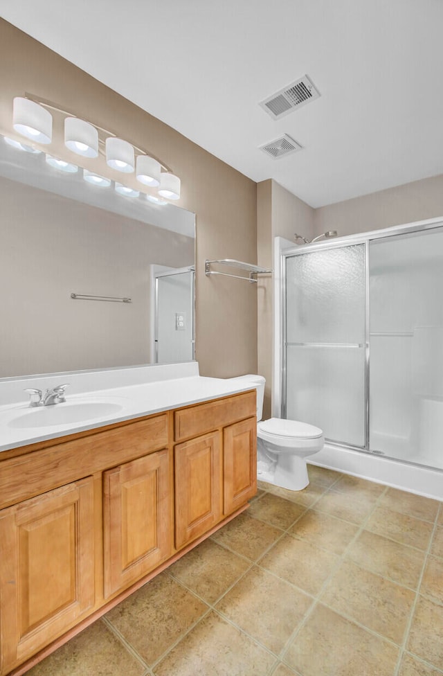 bathroom with vanity, toilet, tile patterned floors, and an enclosed shower