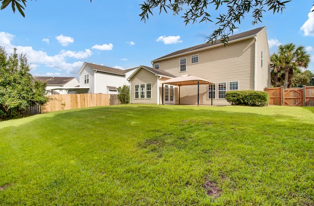 back of house featuring a gazebo and a yard