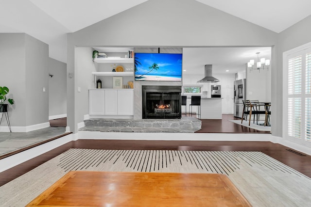 8 Pony Ln, Charleston, SC 29407 - unfurnished living room featuring lofted ceiling, wood finished floors, a lit fireplace, baseboards, and a chandelier