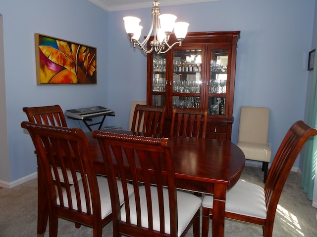 dining room featuring light carpet, crown molding, baseboards, and an inviting chandelier