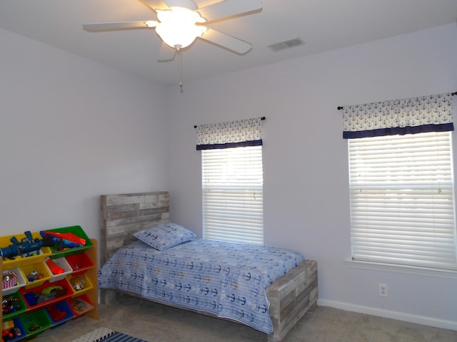 bedroom with carpet floors, baseboards, visible vents, and a ceiling fan