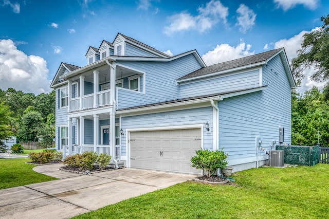 view of front of home featuring a front lawn, cooling unit, a balcony, and a garage