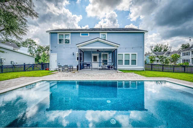 exterior space featuring ceiling fan, a fenced in pool, a patio area, and a yard