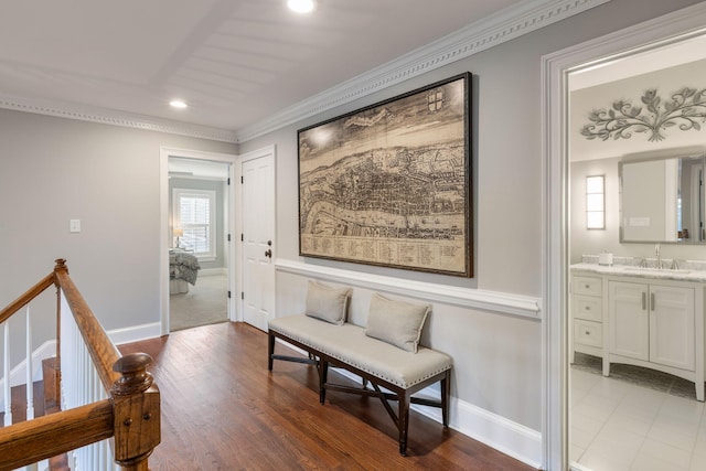 hallway with ornamental molding, hardwood / wood-style flooring, and sink