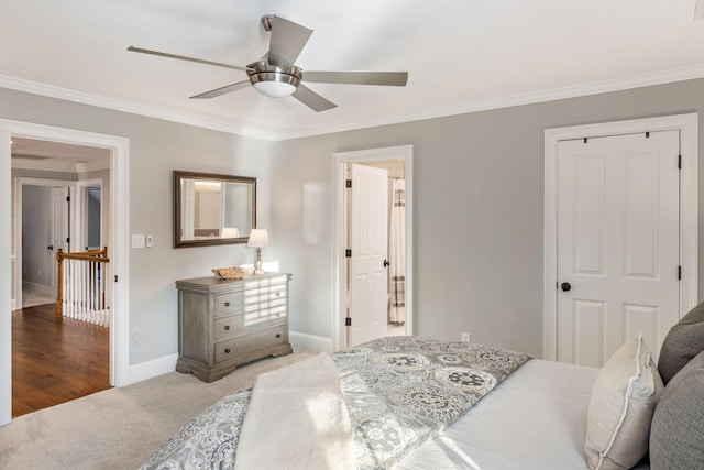 bedroom with ornamental molding, a closet, light colored carpet, and ceiling fan