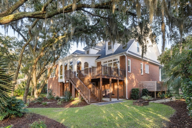 rear view of property with a yard and a deck